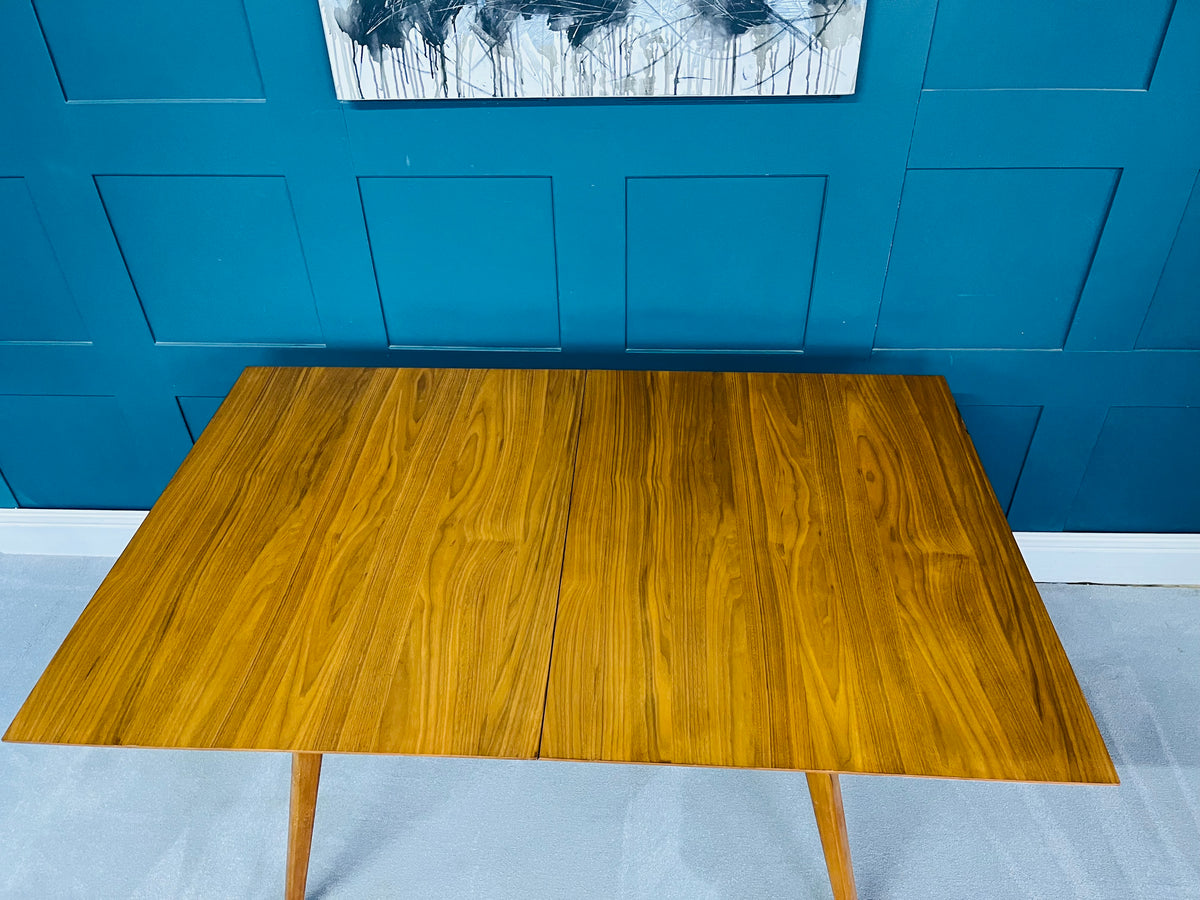 Mid-century modern rectangular dining table by West Elm made of walnut-finished wood, featuring tapered legs and a bevelled edge, sized at 152 cm.