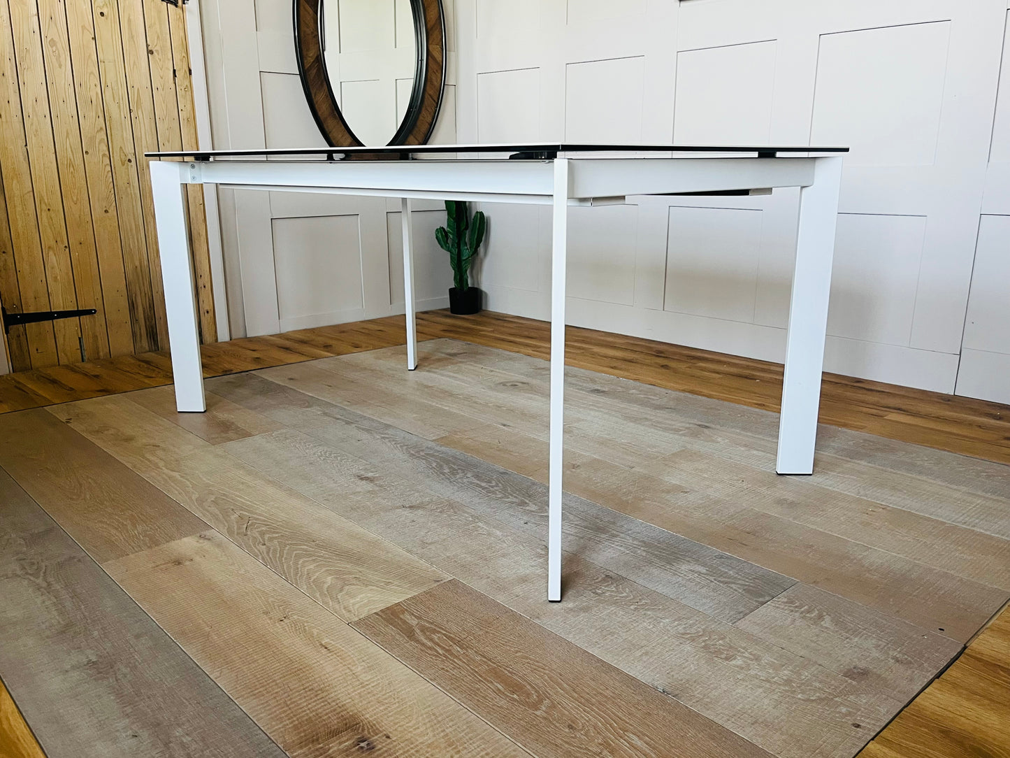 Minimalist 6-seater dining table from John Lewis featuring a pure white ceramic top resting on a matching white lacquered metal frame in a bright, contemporary dining room setting