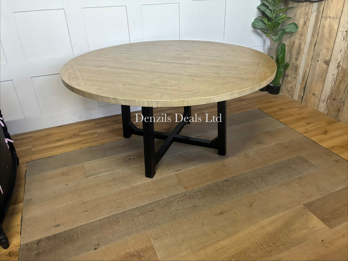 A modern country-style dining room setting showcasing the 160cm round Belluno dining table with its rustic pine top and central black X-frame legs.