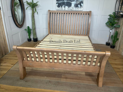 King-size bed frame made from reclaimed natural timber wood, featuring a rustic headboard with unique grain patterns, a sturdy low-profile base, and warm honey-brown tones.