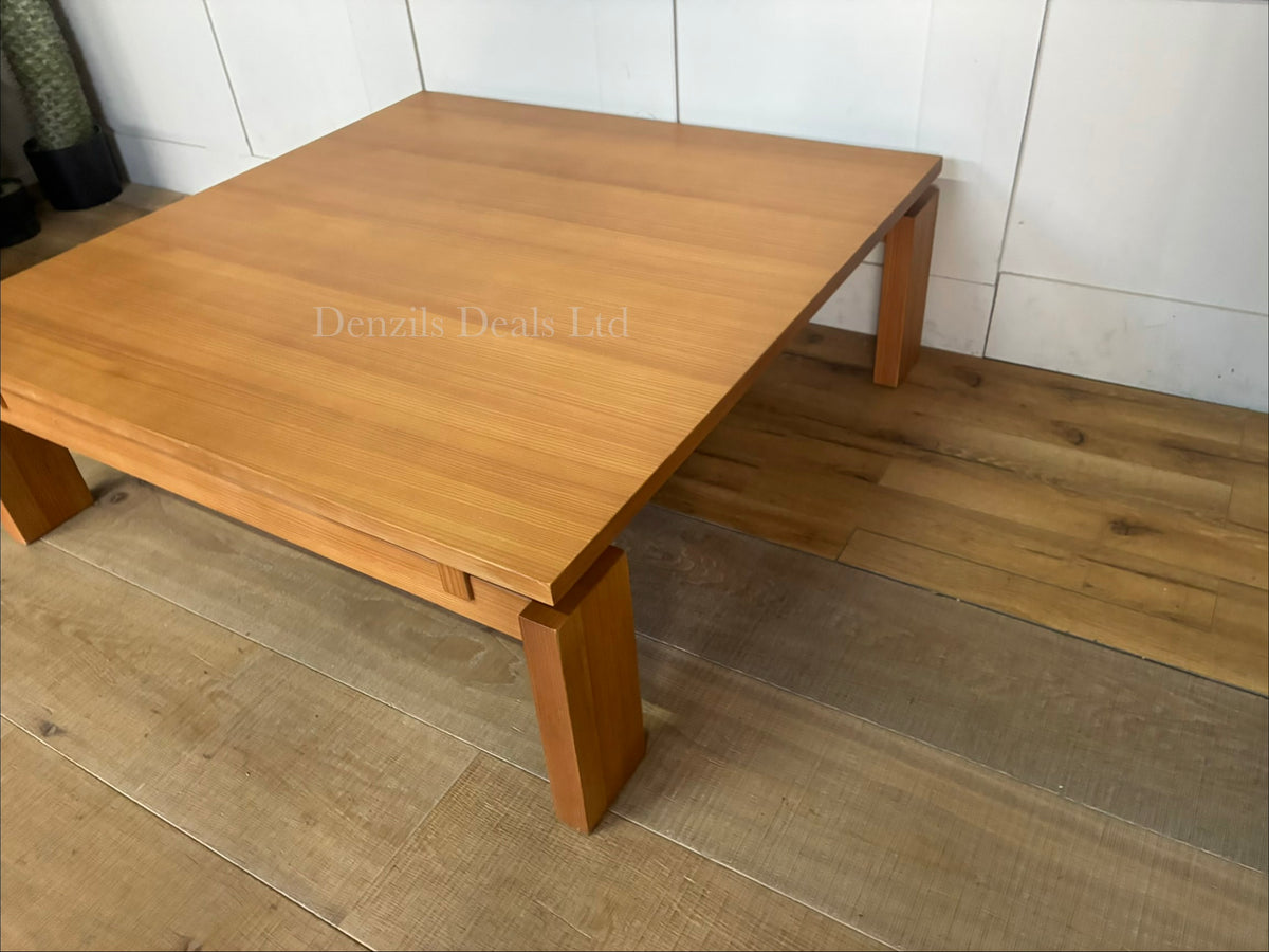 A West Elm Ainsley square coffee table measuring 102 cm with a low-profile design. The table showcases a streamlined top suspended over a structured wood frame with visible craftsmanship detailing, all finished in a warm, rich nutmeg brown veneer.