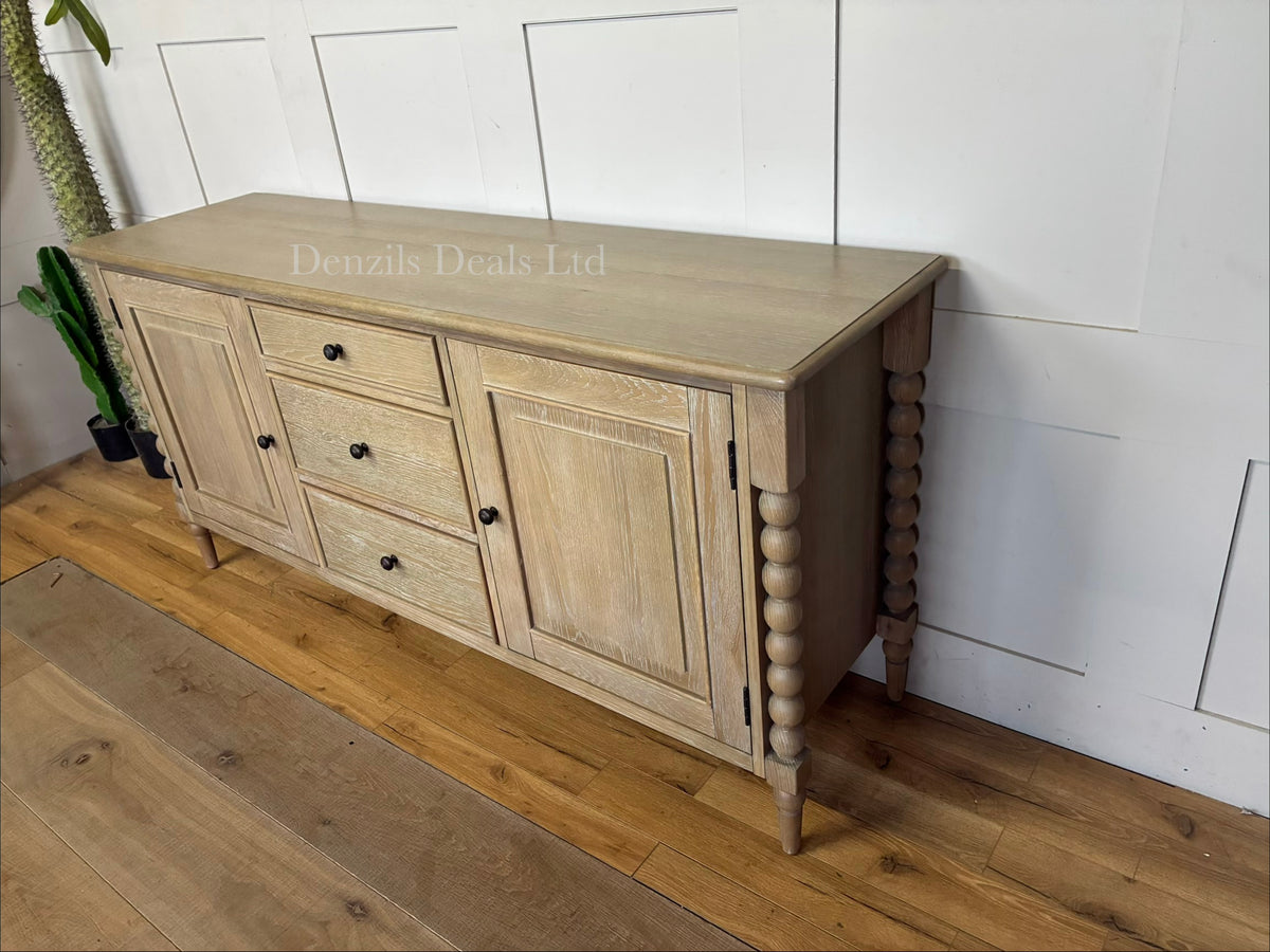 A beautifully crafted light oak furniture piece, the Gallery Direct Bessemer Sideboard, styled in a contemporary living space with its soft, mellow lime wash finish catching the natural room light