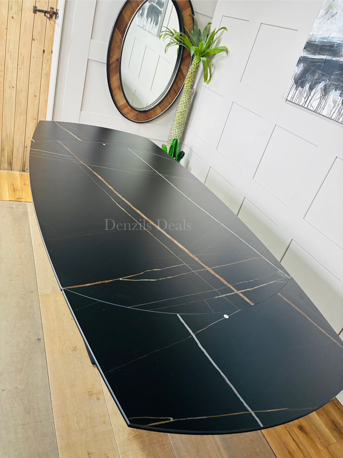 A black ceramic marble-effect dining table extending from 150cm to 220cm, showing the rotating mechanism that reveals side extension leaves to comfortably seat up to 8 people