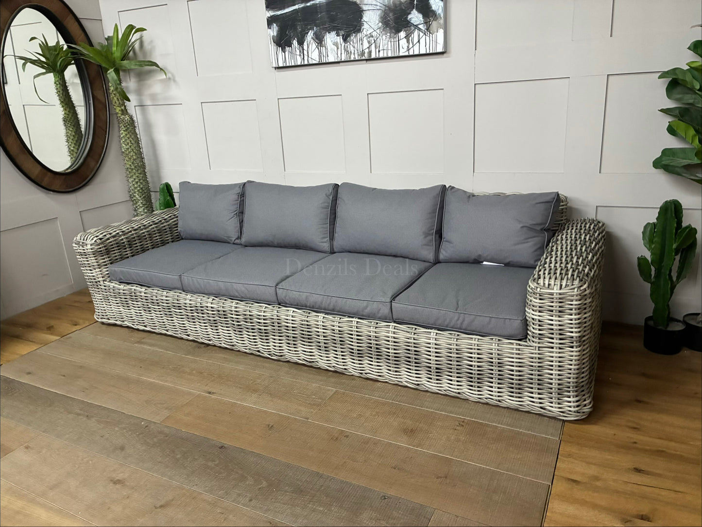 A chunky natural rattan 3-seater garden sofa with deep, neutral-toned outdoor cushions