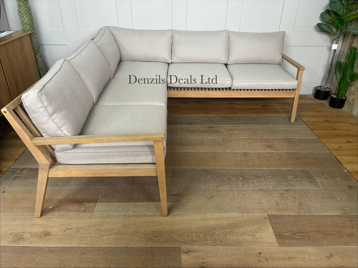 A contemporary John Lewis Mona 4-seater corner garden sofa made from natural-finish acacia wood with cream-coloured seat and back cushions.