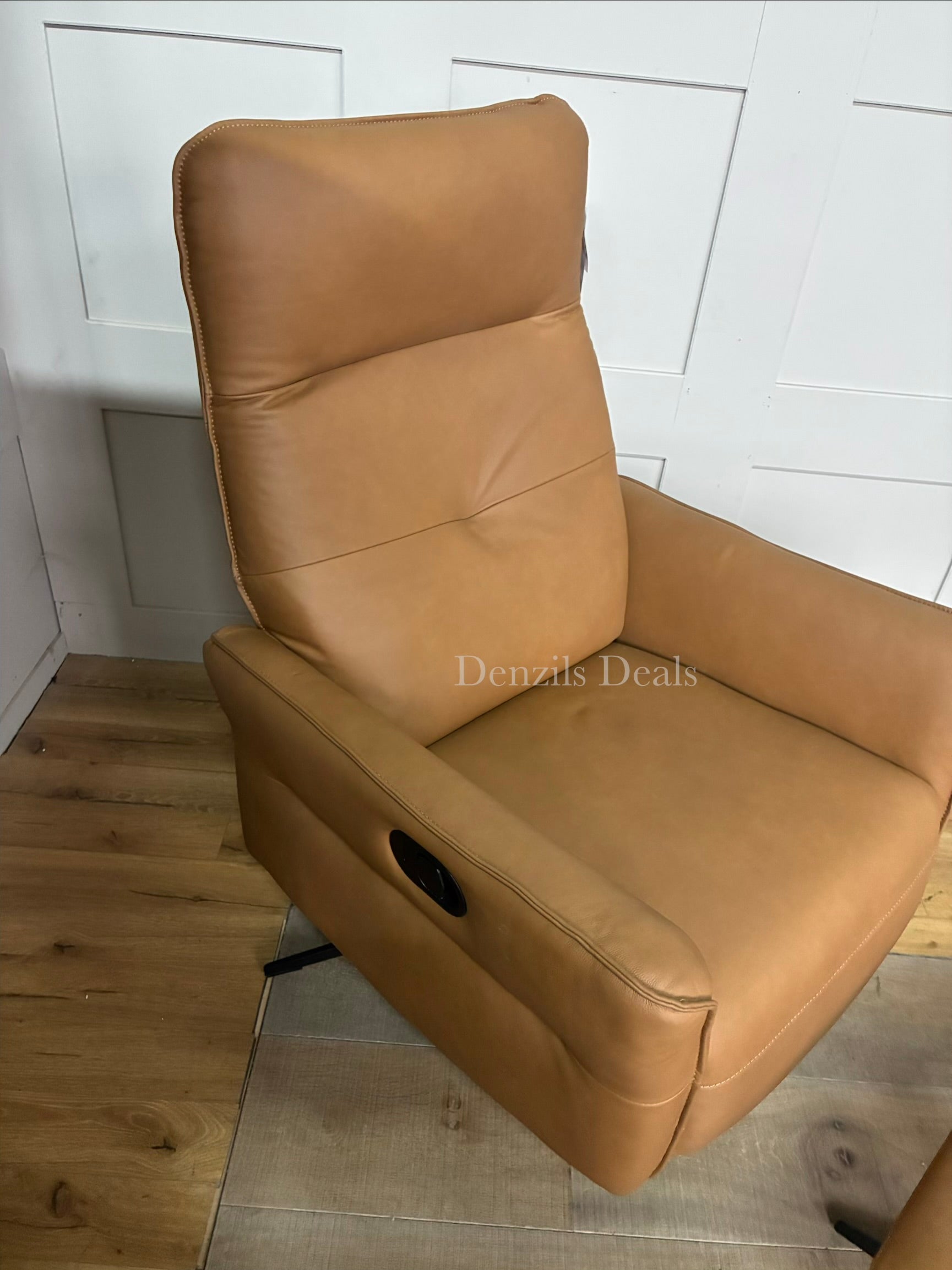 A contemporary John Lewis manual recliner armchair and matching footstool set, upholstered in a warm tan leather showing natural grain characteristics. The armchair features an ergonomic, cushioned silhouette with foam and fibre filling, supported by four sleek, angled metal legs.