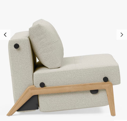 A contemporary Scandinavian-style Innovation Living Cubed 90 convertible armchair upholstered in Mixed Dance Natural fabric—a light beige, textured melange weave. It features a compact, minimalist square profile with clean lines and light oak wooden legs.