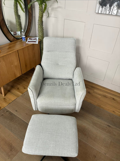 A contemporary ergonomic armchair and footstool set featuring a plush, high-back silhouette covered in textured light grey chenille upholstery. The set is elevated on sleek, angular black metal legs, showcasing a comfortable, modern look for a living room or study.