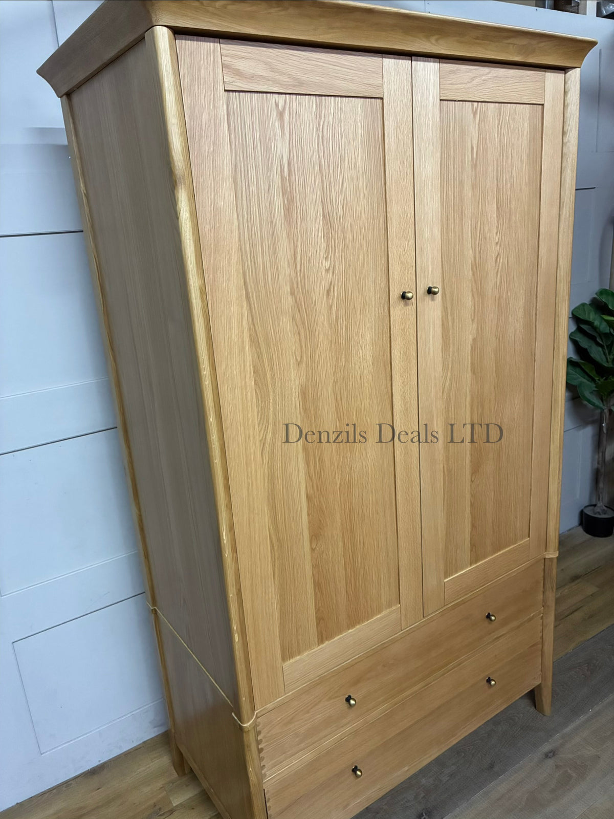 A contemporary two-door double wardrobe crafted from light, natural oak wood, featuring integrated cutout handle slots and a clean, minimalist silhouette.