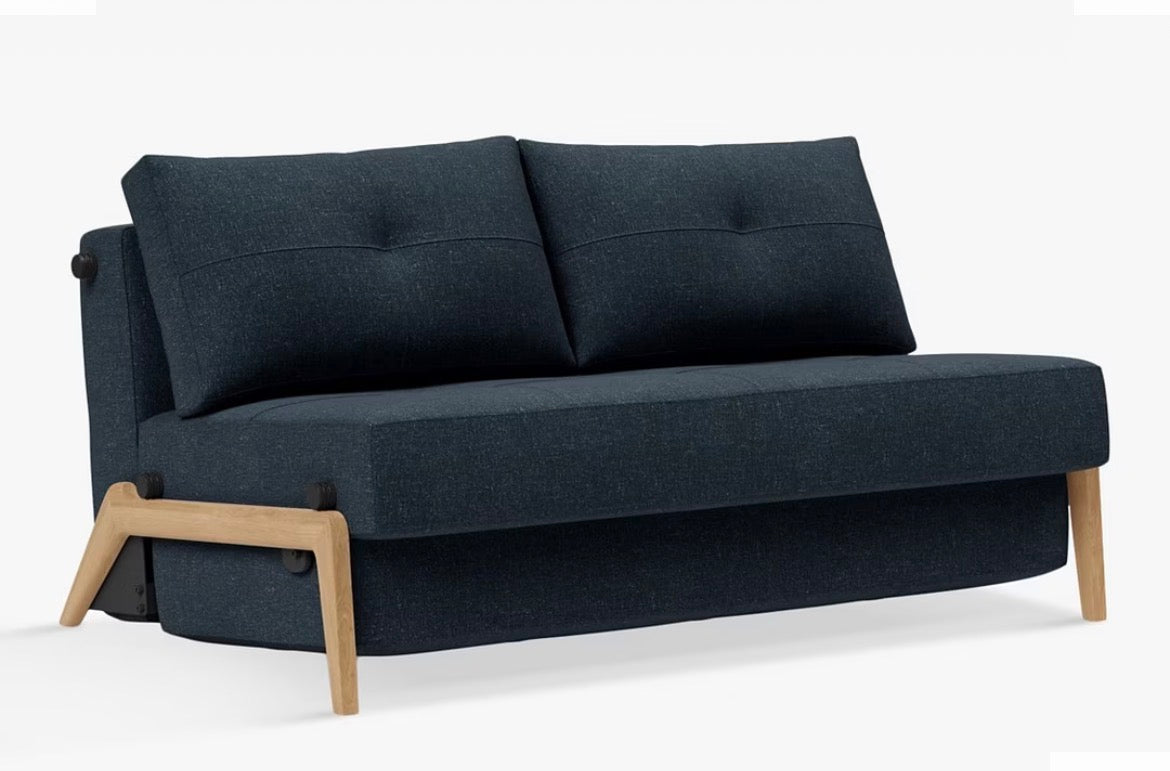 A contemporary two-seater sofa bed from Innovation Living upholstered in a textured, deep Nist Blue 515 fabric, featuring a compact space-saving design with minimalist legs and a clean, modern silhouette.