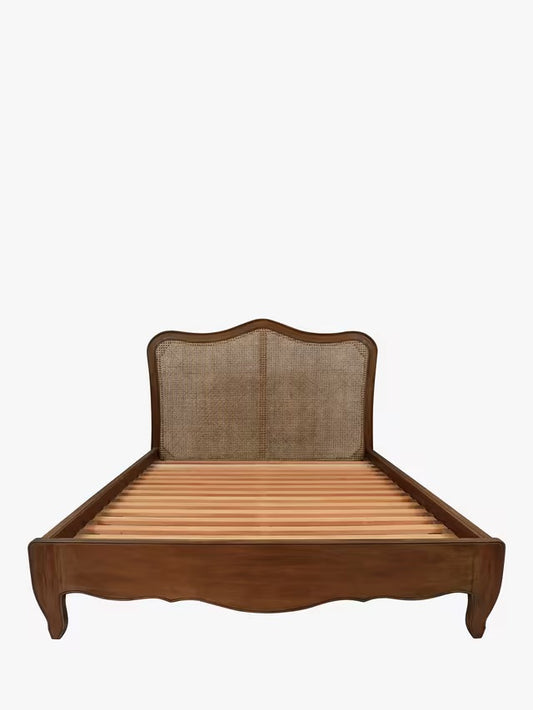 A double-sized Laura Ashley Montpellier bed frame crafted from rich walnut wood, showcasing a high arched headboard with an intricate woven rattan panel, curved French-inspired legs, and profiled side rails.