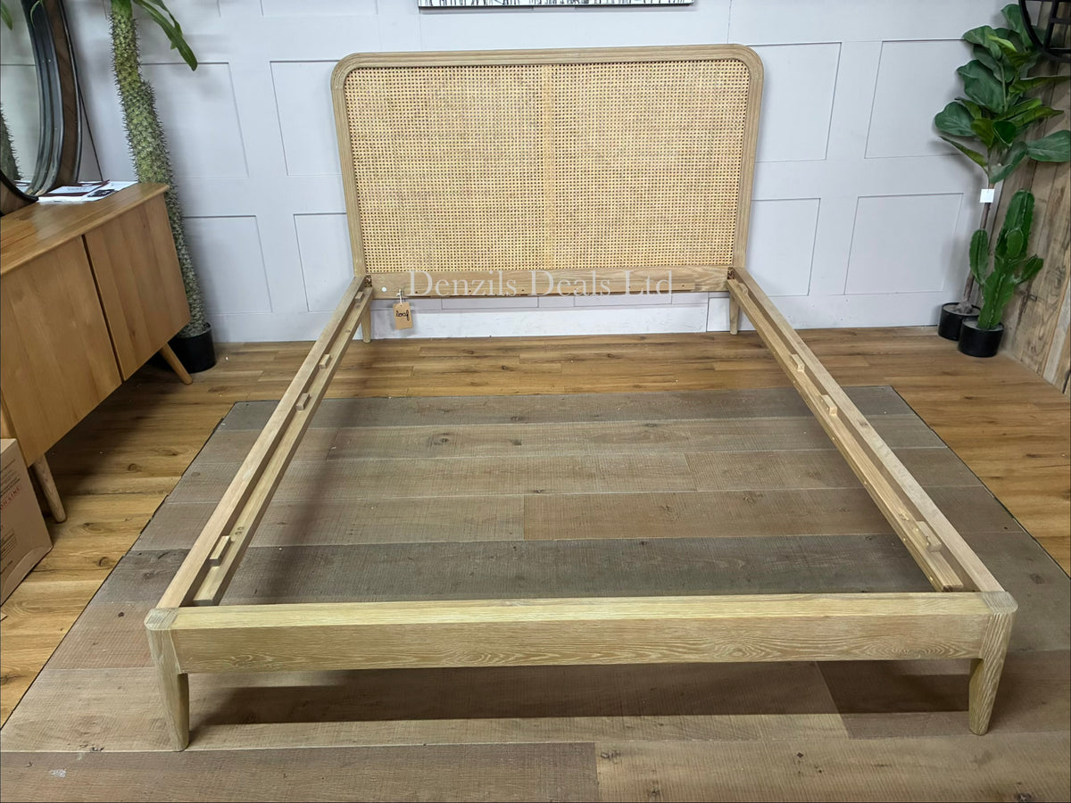 A king-size wooden bed frame made of solid oak and natural woven cane rattan with a curved headboard and simple, clean lines.