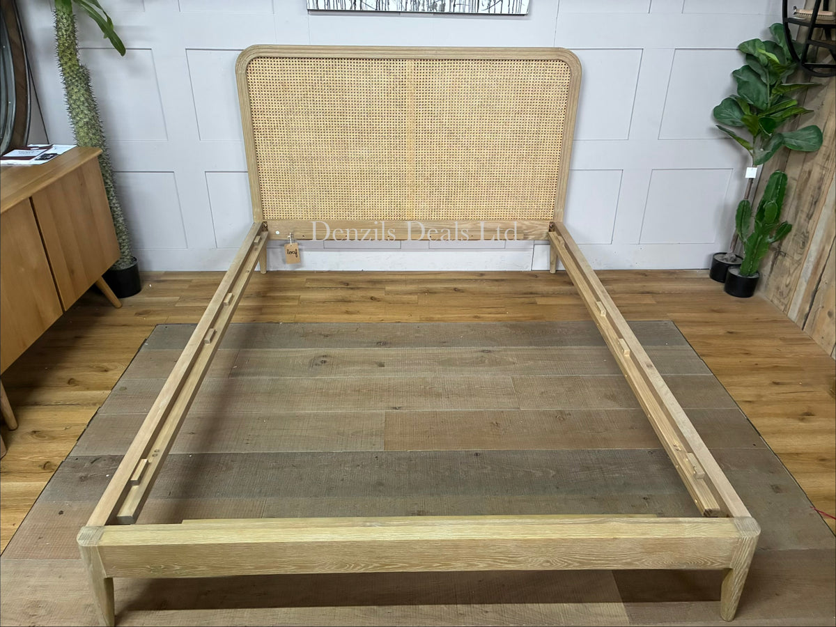 A king-size wooden bed frame made of solid oak and natural woven cane rattan with a curved headboard and simple, clean lines."