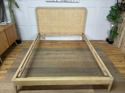 A king-size wooden bed frame made of solid oak and natural woven cane rattan with a curved headboard and simple, clean lines."