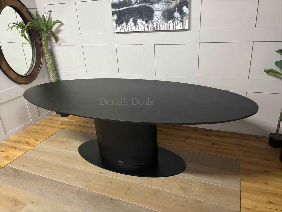 A large 250cm contemporary rectangular dining table by Richmond Interiors. The tabletop is crafted from oak and oak veneer with a dark coffee brown finish that subtly shows the natural wood grain. It is supported by a heavy-duty, modern black iron central pedestal base.