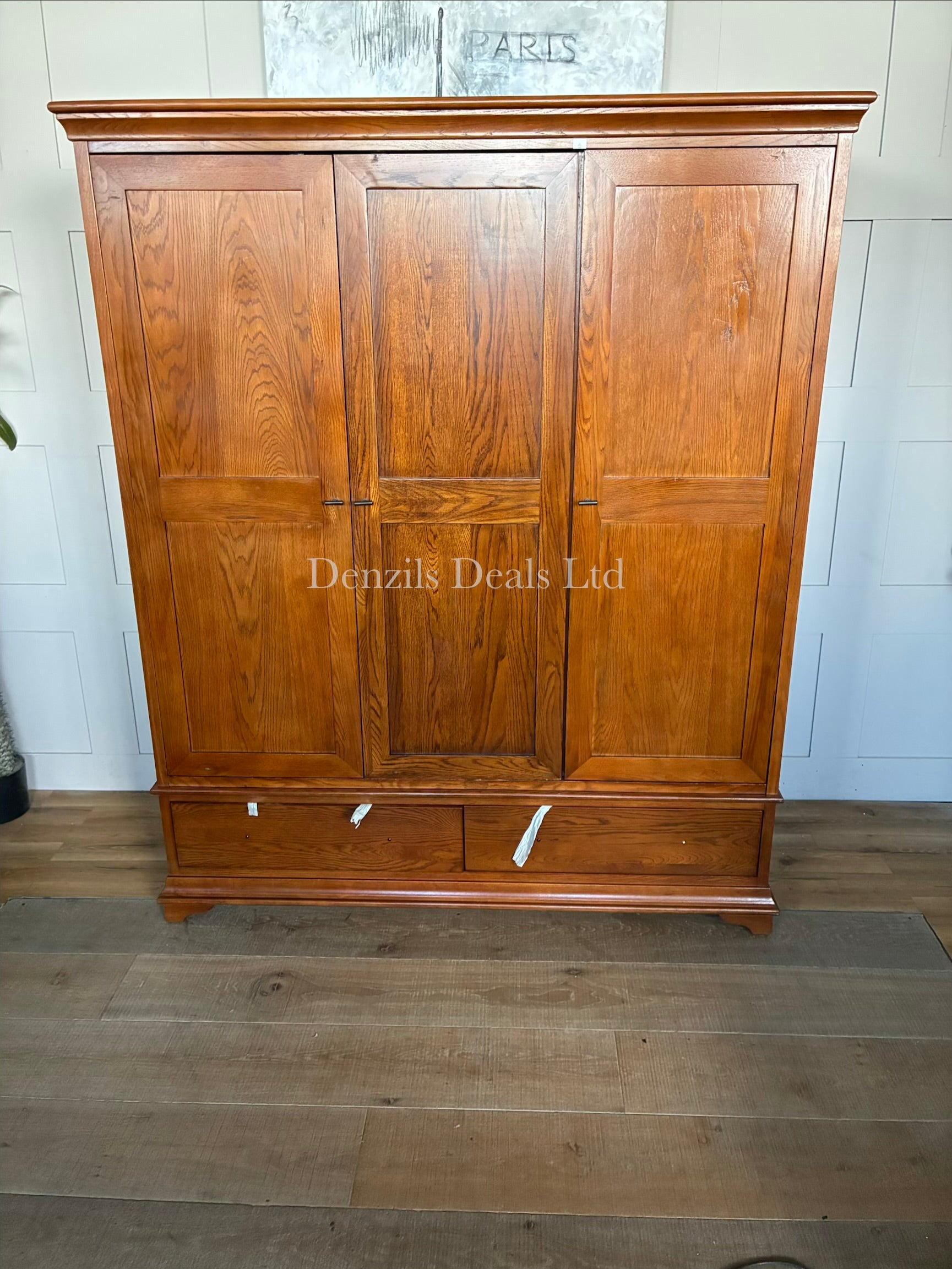 A large, three-door Winchcombe Dark Oak Triple Wardrobe by The Cotswold Company, featuring a traditional rich dark brown wood grain finish, an elegantly curved bow-front profile, delicate top cornicing, and antiqued metal handles on the doors above two deep base drawers.