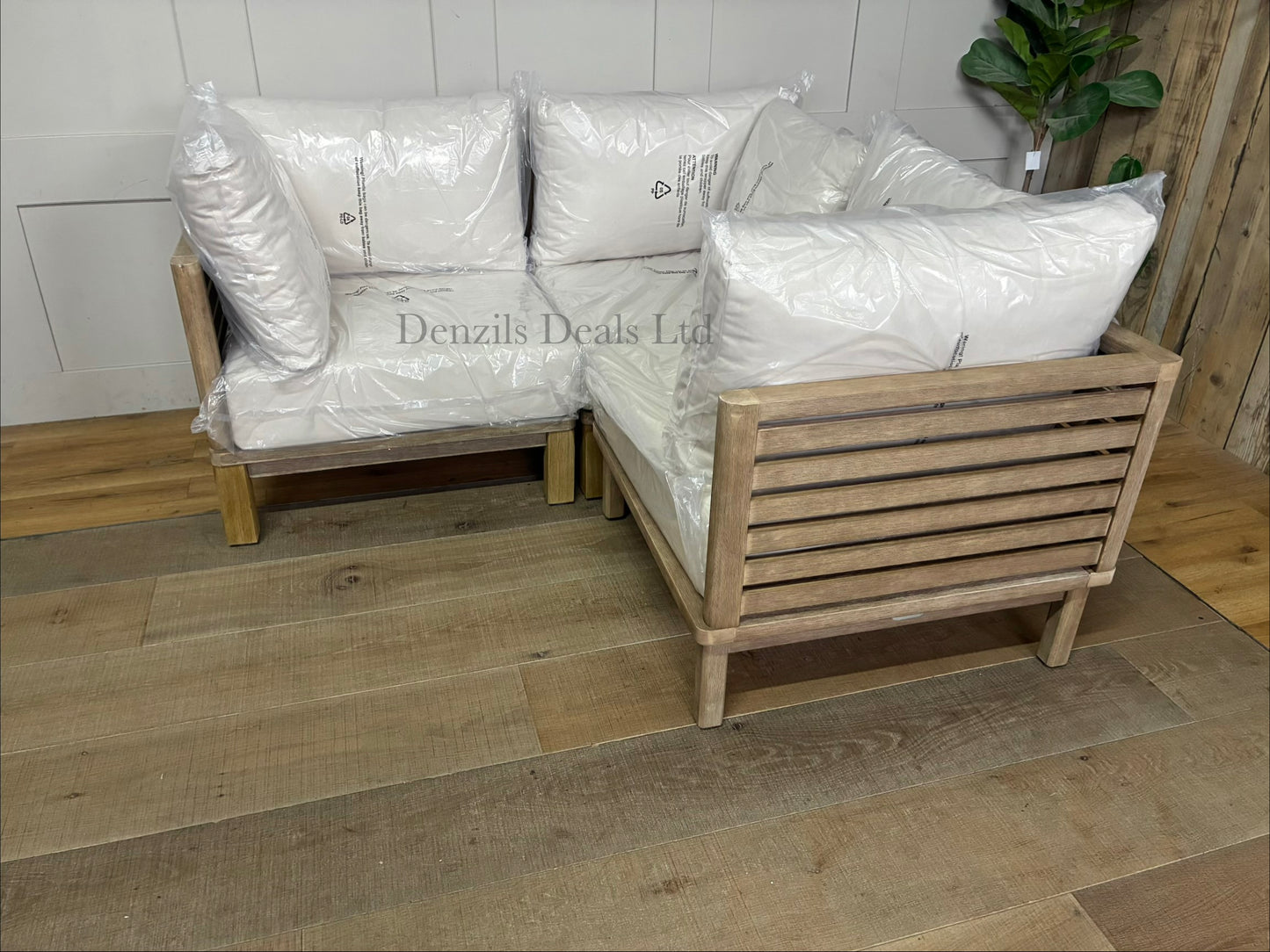 Three low-slung modular garden corner chair made from brushed eucalyptus wood with a modern slatted design and thick seat and backrest cushions, combined to make a perfect corner sofa