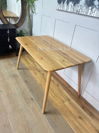 A mid-century modern style John Lewis Greenwood dining table crafted from solid oak with a light Bianco oil finish, featuring clean lines, tapered legs, and a 130cm round tabletop showcasing natural wood grain