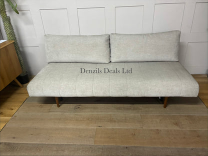A minimalist Innovation Living Ripple two-seater sofa bed upholstered in smooth, neutral Avella Sand 280 fabric. The sofa features a clean, subdued modern design with tight cushioning, sleek wooden legs, and a sturdy metal frame.