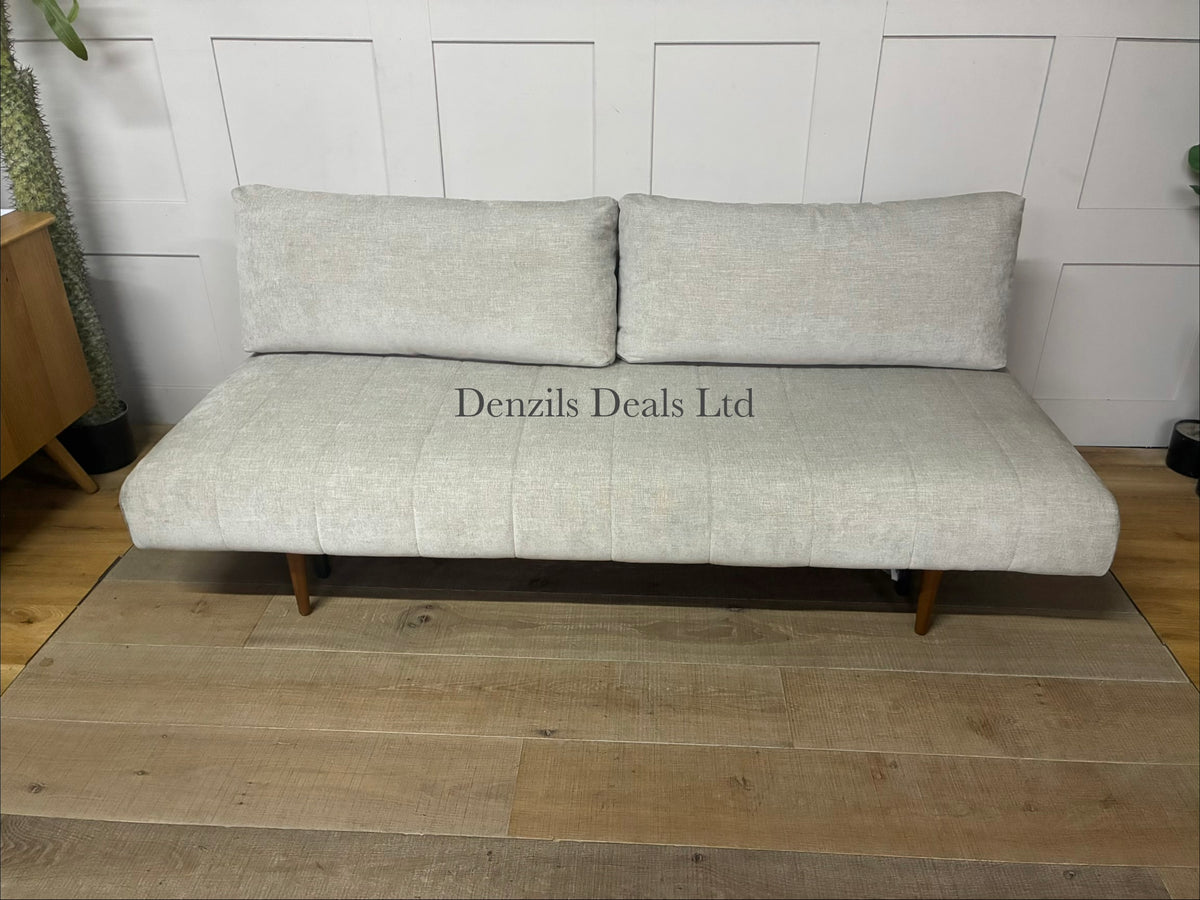 A minimalist Innovation Living Ripple two-seater sofa bed upholstered in smooth, neutral Avella Sand 280 fabric. The sofa features a clean, subdued modern design with tight cushioning, sleek wooden legs, and a sturdy metal frame.