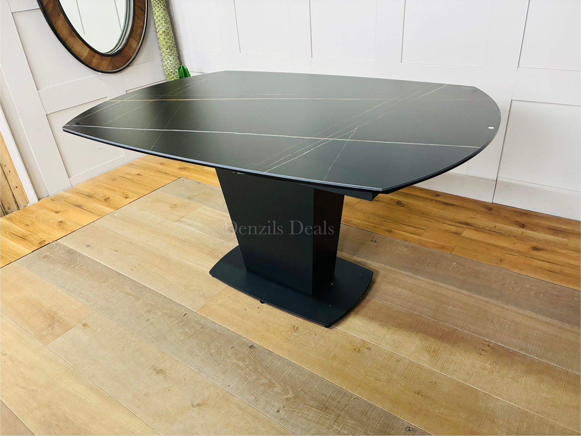 A modern black ceramic dining table with a distinctive white-veined marble effect. The table features an extendable top and a sleek, curved fiberglass tulip-style pedestal base. 