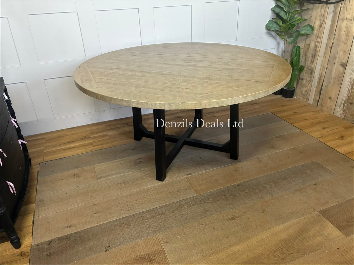 A modern country-style dining room setting showcasing the 160cm round Belluno dining table with its rustic pine top and central black X-frame legs.