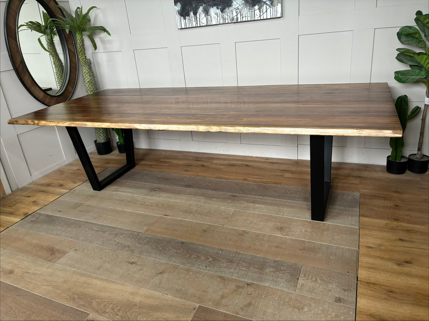 A modern industrial Bartolo dining table by Nick Scali. The rectangular table features a thick, warm-toned Tasmanian Blackwood tabletop with organic, wavy live edges that highlight the natural wood grain. The top rests on two heavy-duty, black powder-coated steel sleigh-style legs at either end, blending rustic warmth with a clean, industrial look