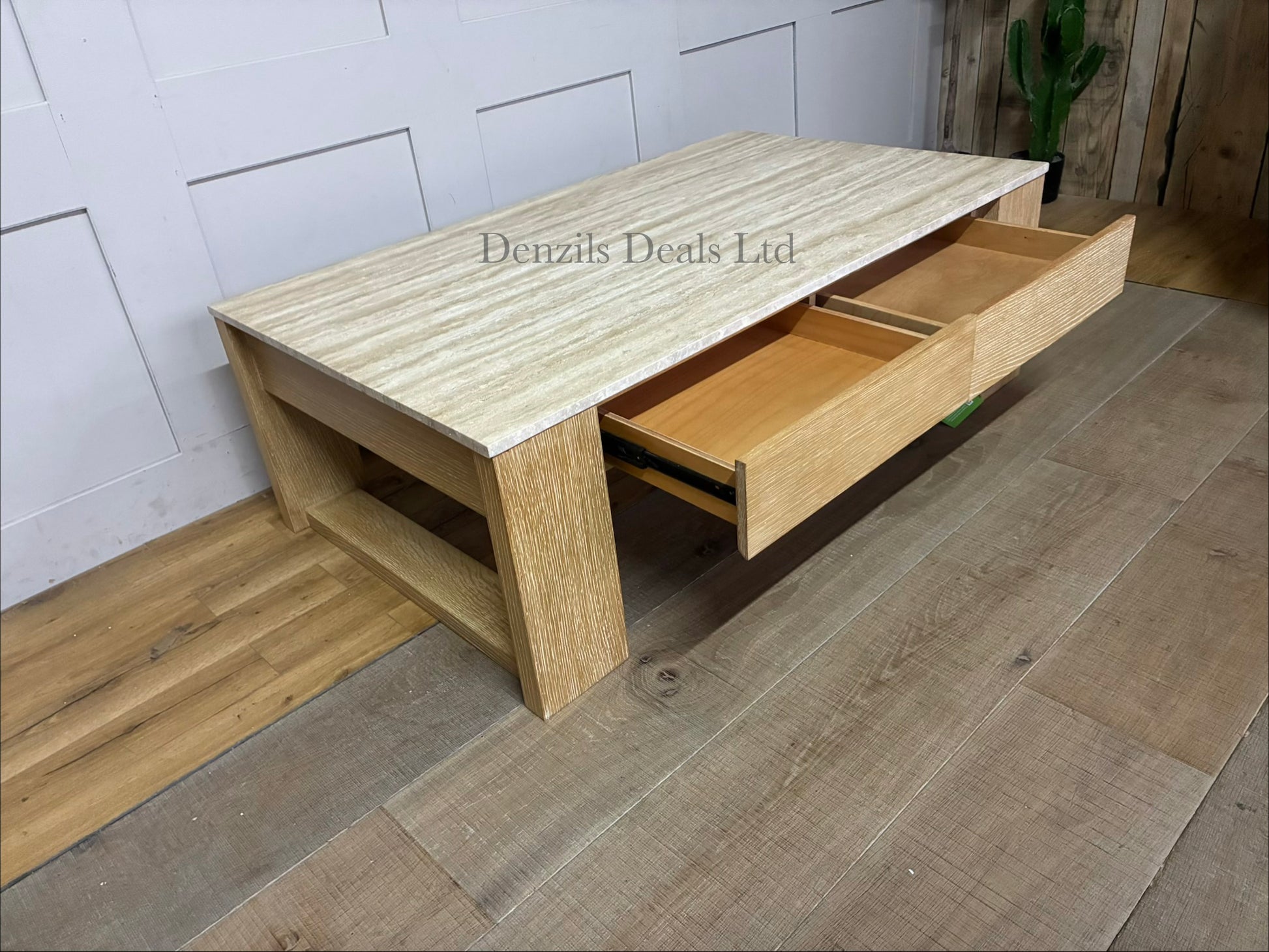 A modern rustic rectangular coffee table featuring a thick top made of natural travertine stone with subtle cream and beige veining. The stone top sits flush over a structured wood base finished in a muted, cool grey-beige "Fog" tone. The front of the table includes two wide, hardware-free storage drawers that showcase a natural, straight wood grain pattern