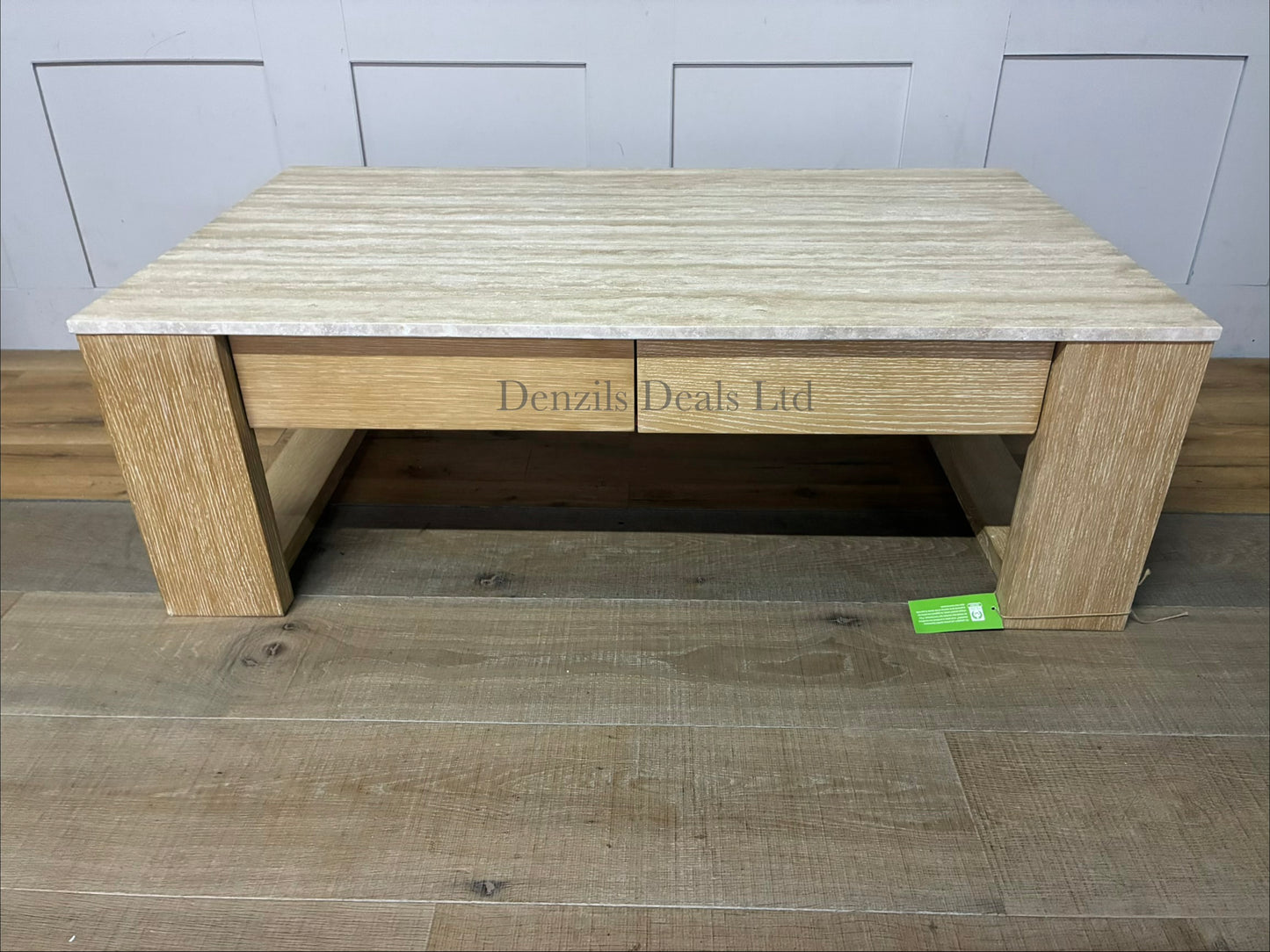 A modern rustic rectangular coffee table featuring a thick top made of natural travertine stone with subtle cream and beige veining. The stone top sits flush over a structured wood base finished in a muted, cool grey-beige "Fog" tone. The front of the table includes two wide, hardware-free storage drawers that showcase a natural, straight wood grain pattern