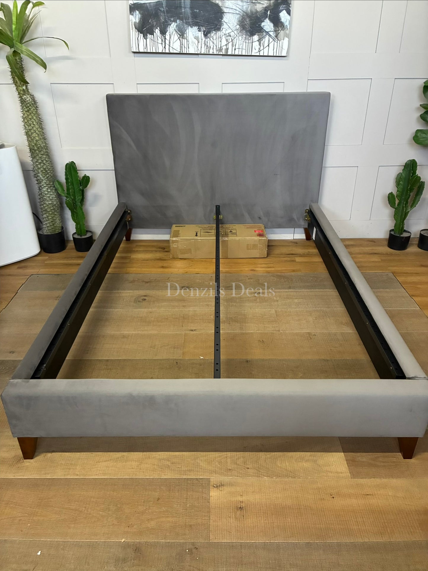 A modern upholstered double bed with a grey velvet headboard, styled in a contemporary bedroom setting.
