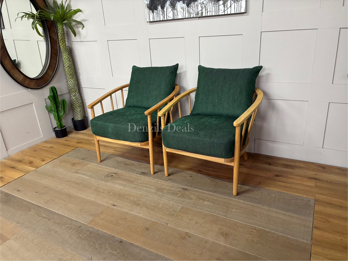 A pair of John Lewis Frome armchairs upholstered in deep forest green fabric with solid oak bases.