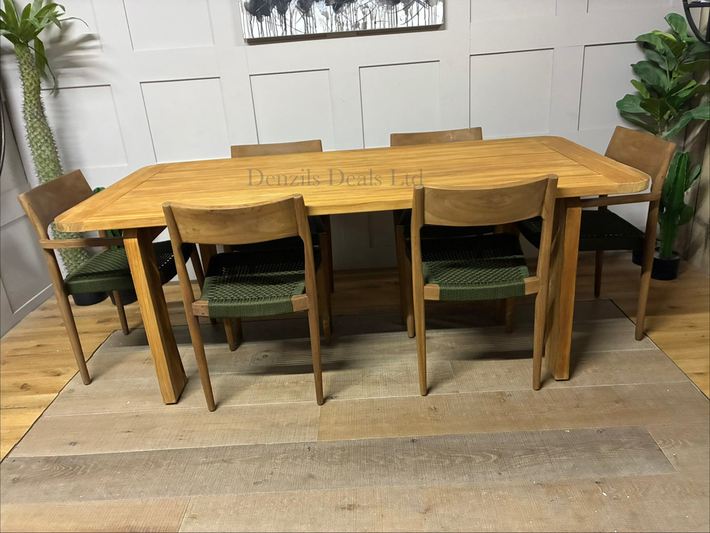A pair of contemporary Terra garden dining chairs with Scandinavian-inspired teak wood frames and plush, neutral shower-resistant seats."