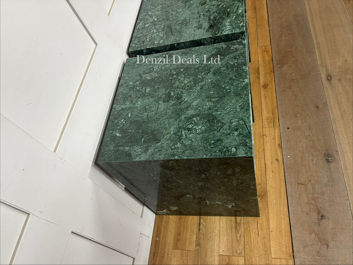 A pair of modern side tables crafted from smooth, solid green marble with natural white veining, featuring an open, minimalist structural silhouette and a polished finish
