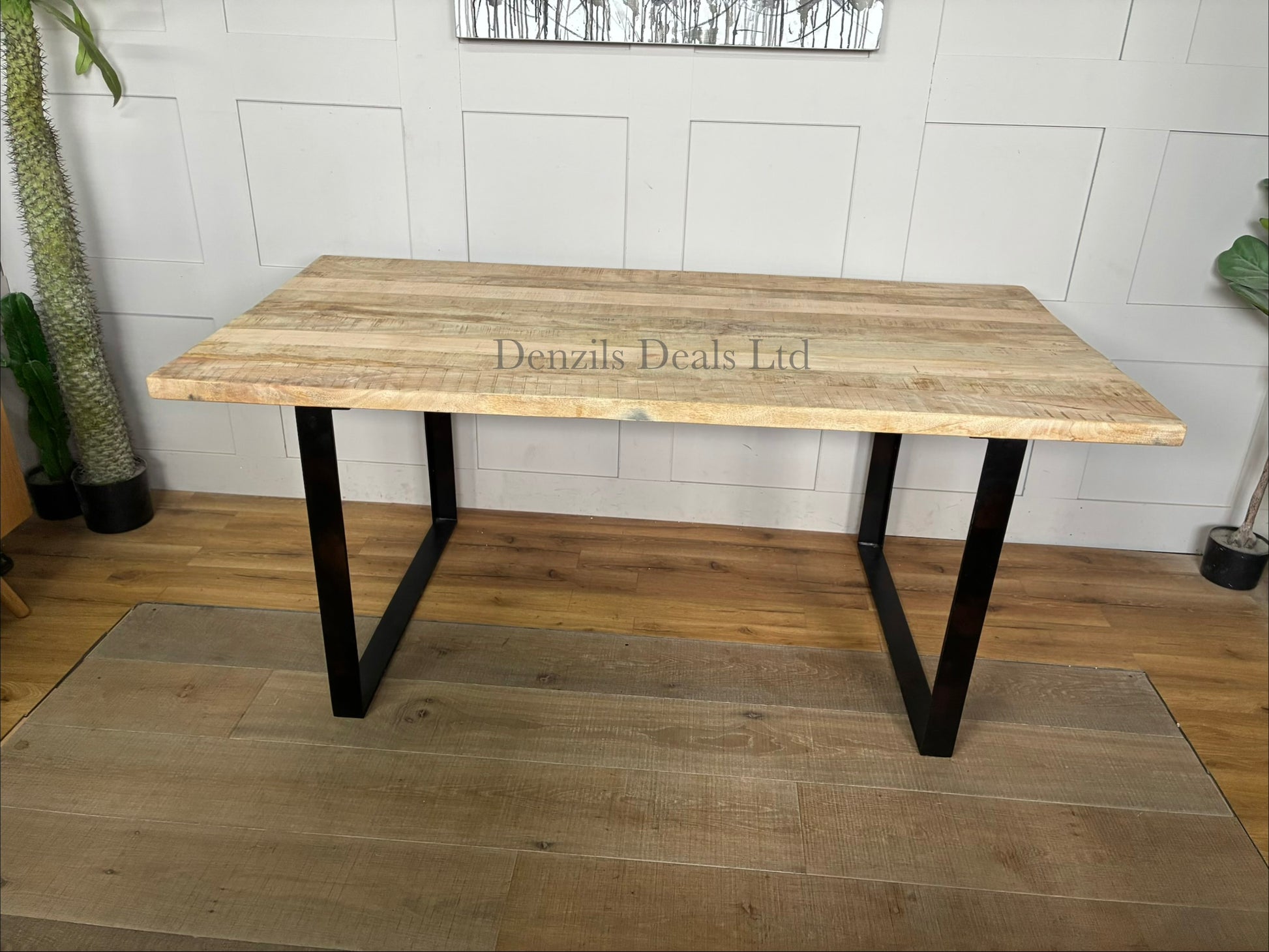 A rectangular 6-seater dining table showcasing a thick, natural mango wood top with prominent organic grain patterns, supported by a strong black industrial-style angular iron base