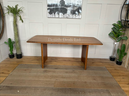 A rectangular natural wood dining table with a herringbone pattern surface and sturdy matching legs, sized for six seats."