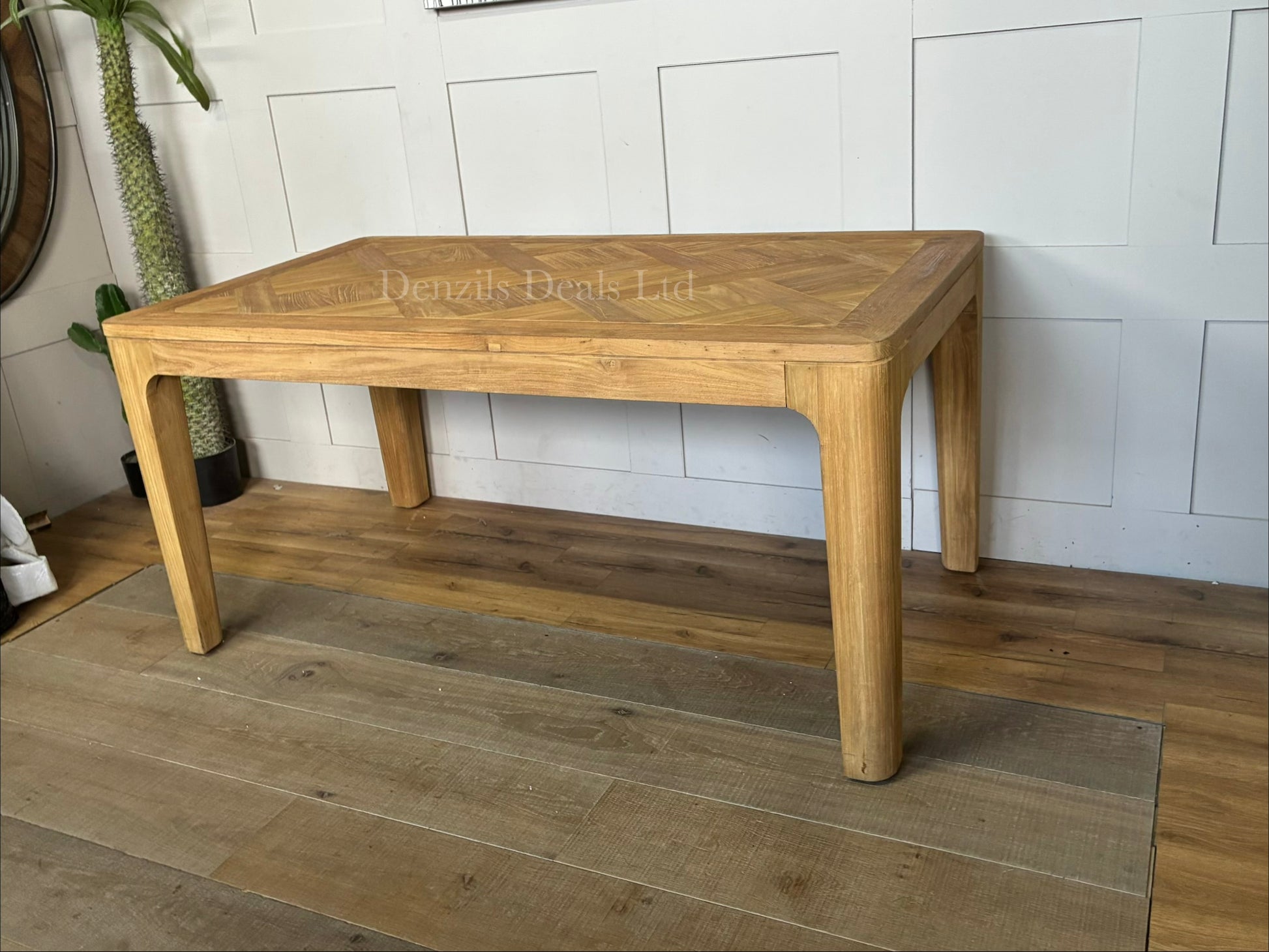 "A rectangular dining table crafted from light-toned reclaimed solid teak wood, featuring a subtle marquetry-patterned tabletop and sturdy wooden legs