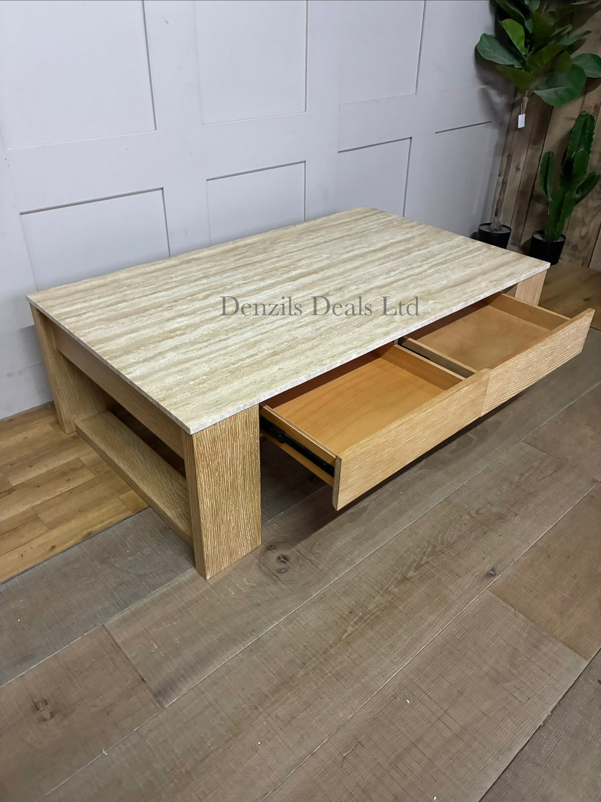 A rectangular low-profile coffee table with a natural cream travertine stone top and a light grey oak wood frame featuring two storage drawers.