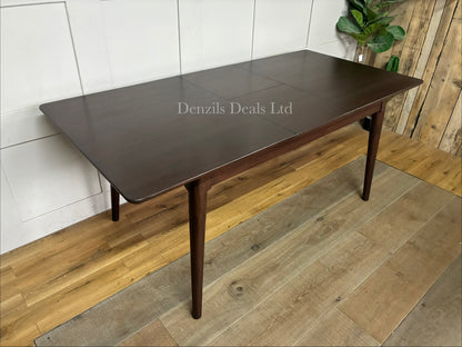 A rectangular mid-century modern dark walnut dining table from the Fishe & Lilly Norway collection, showcasing a rich wood grain and minimalist legs, styled to comfortably seat 4 to 6 people.