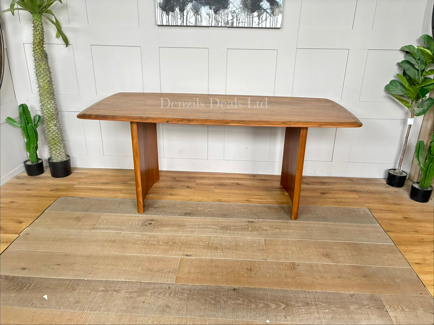 A rectangular natural wood dining table with a herringbone pattern surface and sturdy matching legs, sized for six seats."