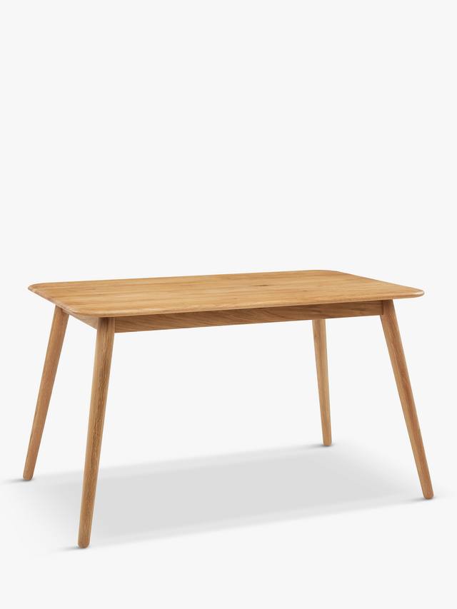 A round wooden dining table with a smooth solid oak top finished in a light bianco oil, supported by simple wooden legs