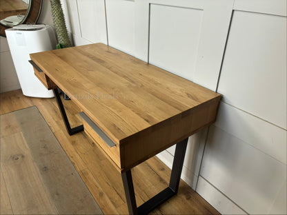 A rustic, light oak writing desk with natural wood grain and an industrial-edged welded iron base.