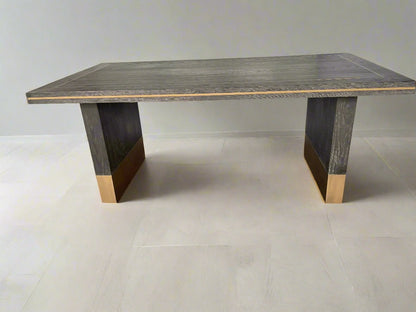 A small rectangular Richmond Interiors Hunter dining table featuring a black oak veneer tabletop with matte brushed gold metal legs and geometric corner inlay details. 