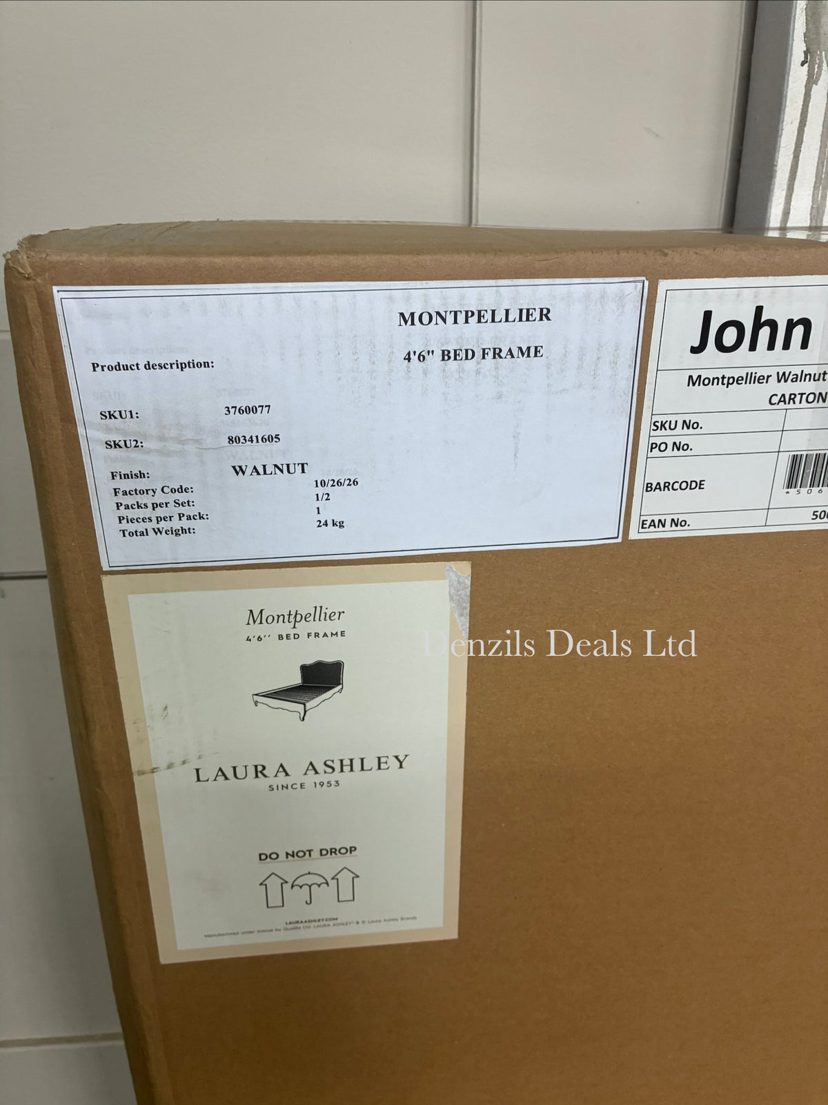 A stately, French-inspired double bed frame from the Laura Ashley Montpellier collection. The bed features a prominent, high arched headboard inset with a light-coloured woven rattan panel that contrasts softly against a dark walnut-stained solid wood frame. The design includes elegant curved legs, profiled side rails, and a clean, low-profile footboard. The mattress area is empty, revealing a supportive solid wood slat base.