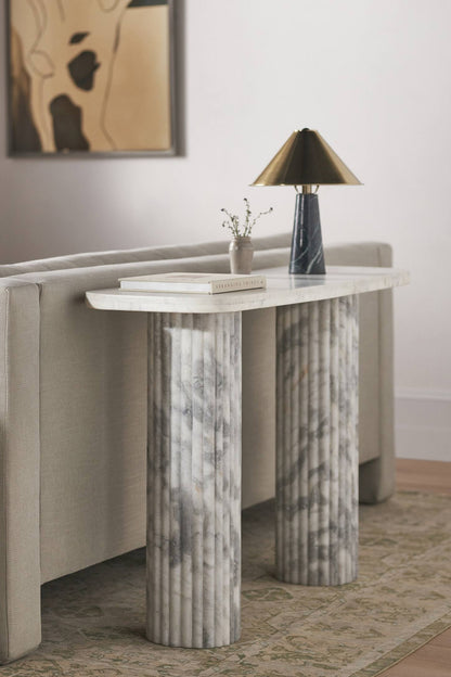 A stately rectangular Anthropologie Kanta console table crafted entirely from pure off-white marble, featuring a smooth top and heavily textured, fluted block legs.