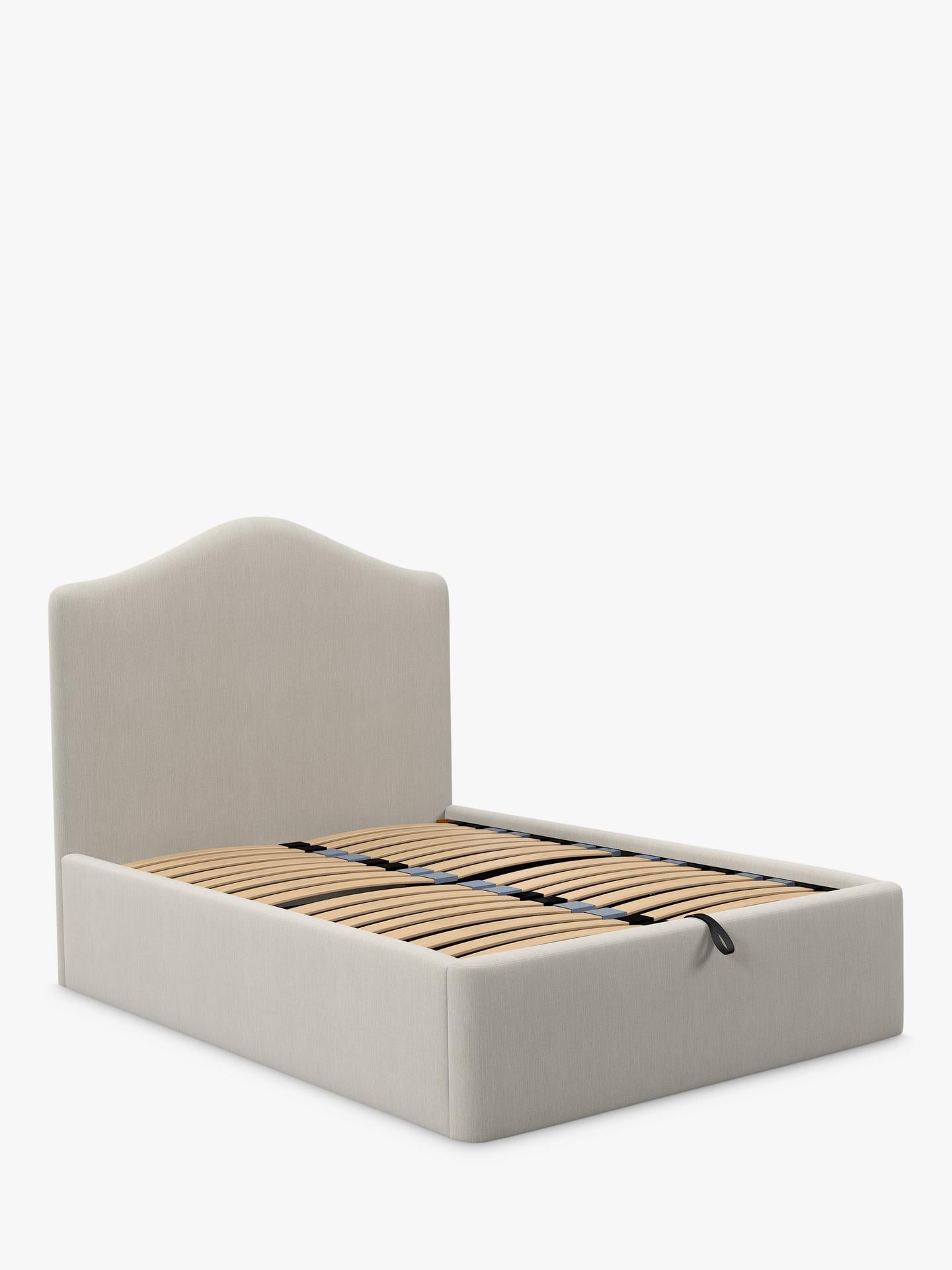 A super king size John Lewis Alice ottoman bed frame in beige cotton-effect fabric, featuring a tall button-tufted headboard and a gas-lift base opened to show the large under-bed storage area.