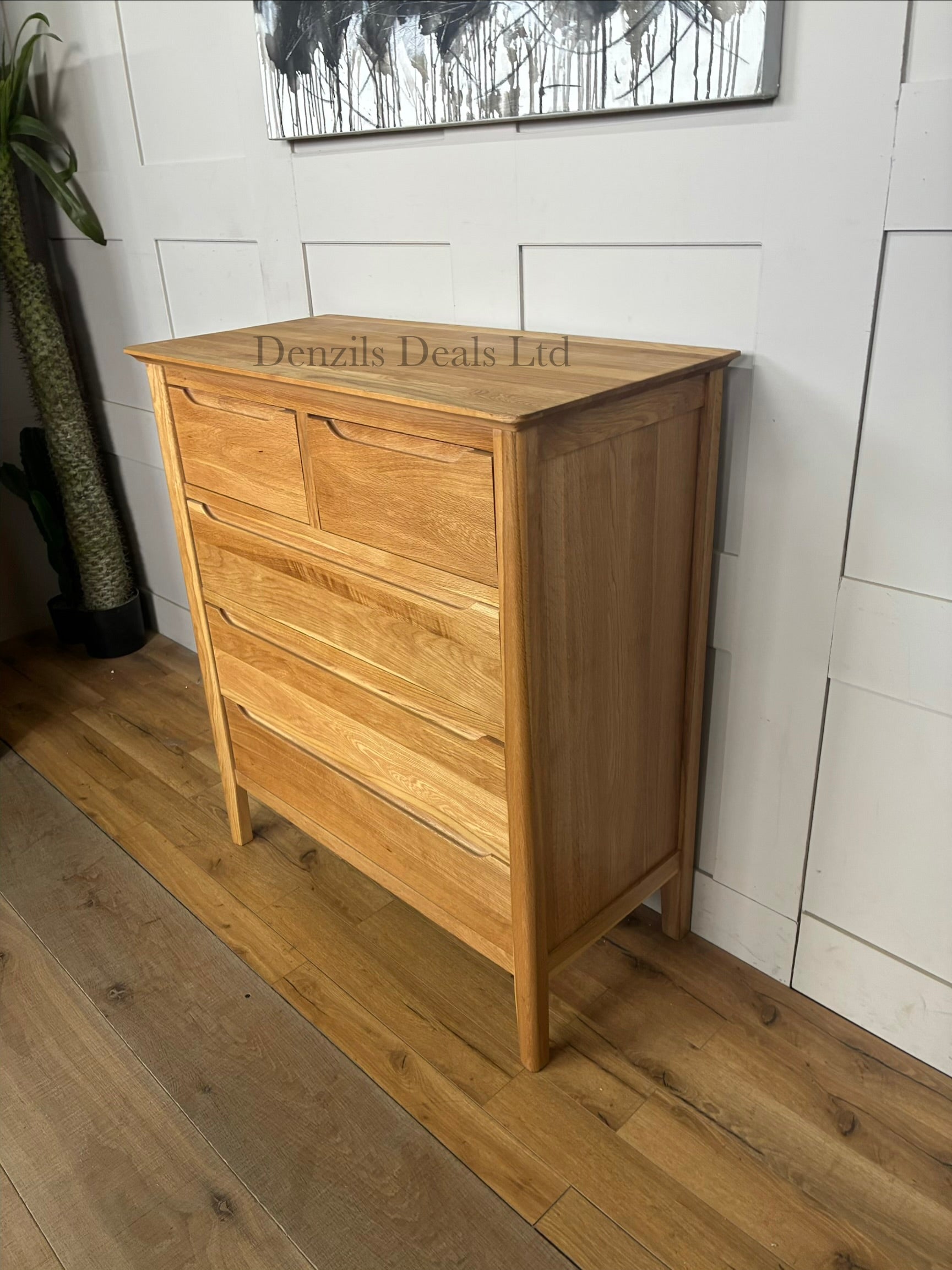 A tall, slender Copenhagen 5-drawer tallboy chest of drawers from Oak Furnitureland, constructed from 100% solid natural oak. Shows five vertically stacked drawers with recessed handle cutouts, softly rounded top corners, and short tapered legs