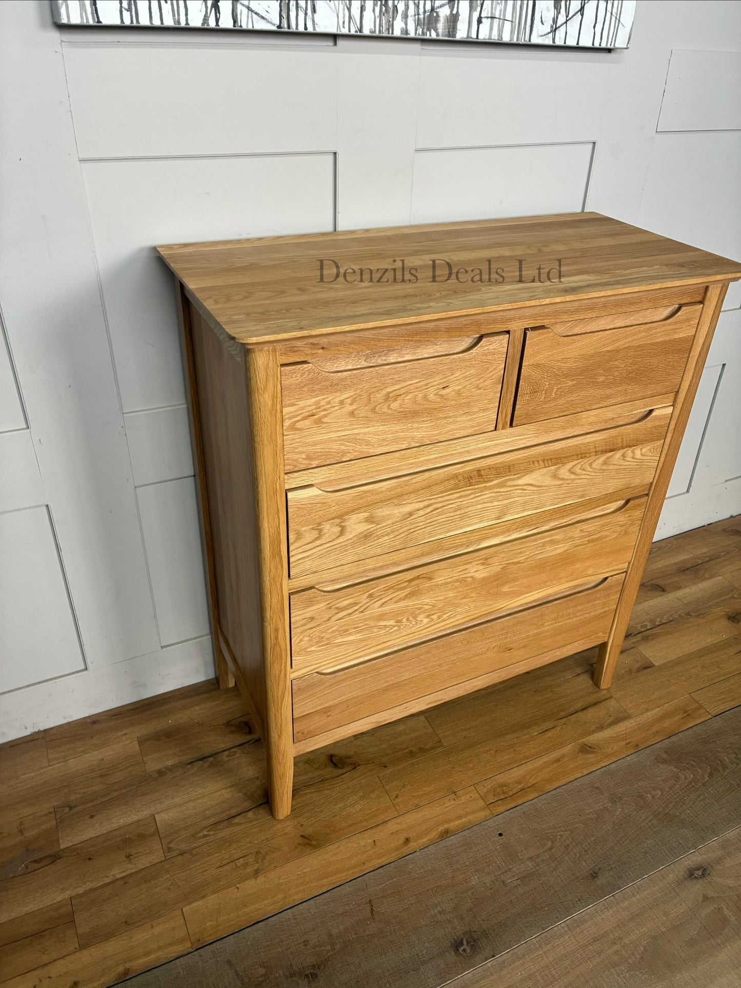 A tall, slender Copenhagen 5-drawer tallboy chest of drawers from Oak Furnitureland, constructed from 100% solid natural oak. Shows five vertically stacked drawers with recessed handle cutouts, softly rounded top corners, and short tapered legs