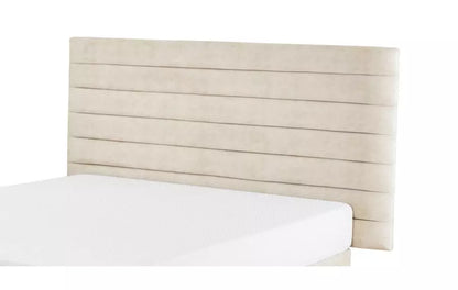 A wall-mounted DFS Karina rectangular headboard panel measuring 90x180cm, upholstered in Gaia Cream plush recycled velvet with vertical channel stitching.