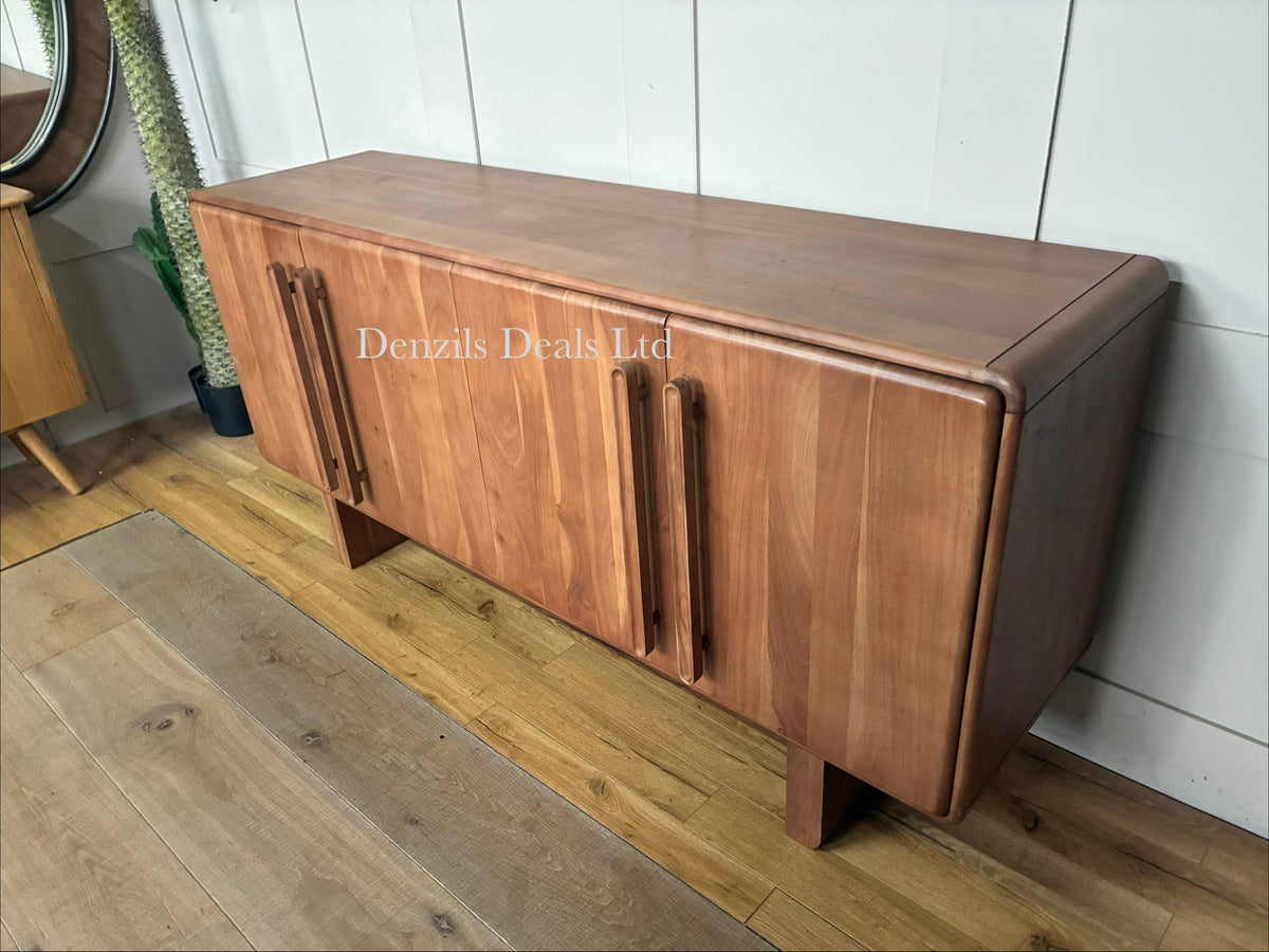 A wide, natural-finish acacia wood sideboard with four doors featuring a distinct panelled design. The furniture piece exhibits a warm wood grain, softly rounded corners, and a seamless, modern profile standing flat on the floor.