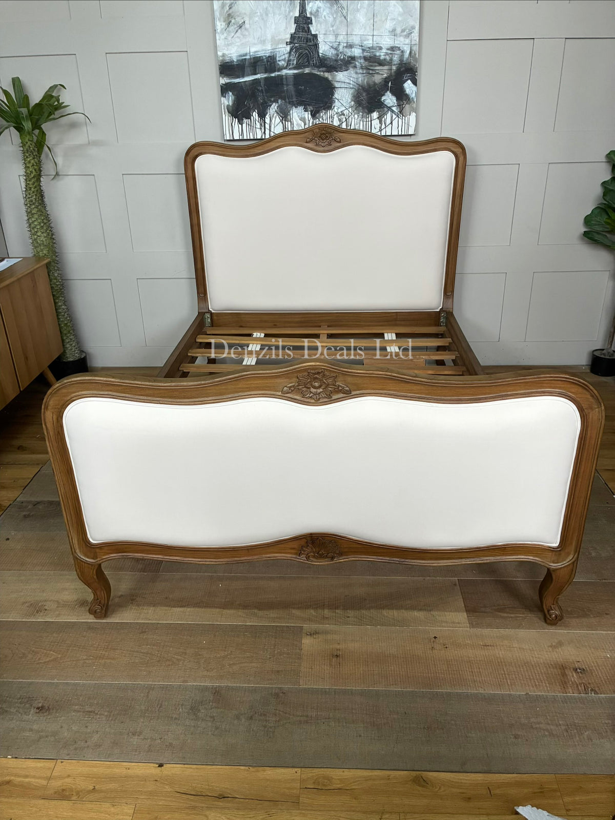 An antique French style wooden bed frame crafted from natural solid Mindy wood, featuring a light whitewash finish, ornate hand-carved detailing, a curved headboard, and a slatted base